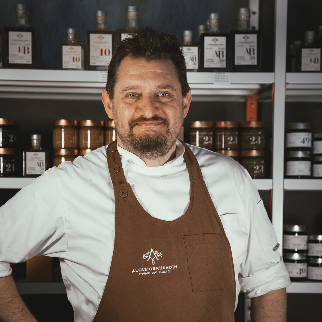 Alessio Brusadin in front of the shelves of jars and liqueurs in the Brugnera workshop