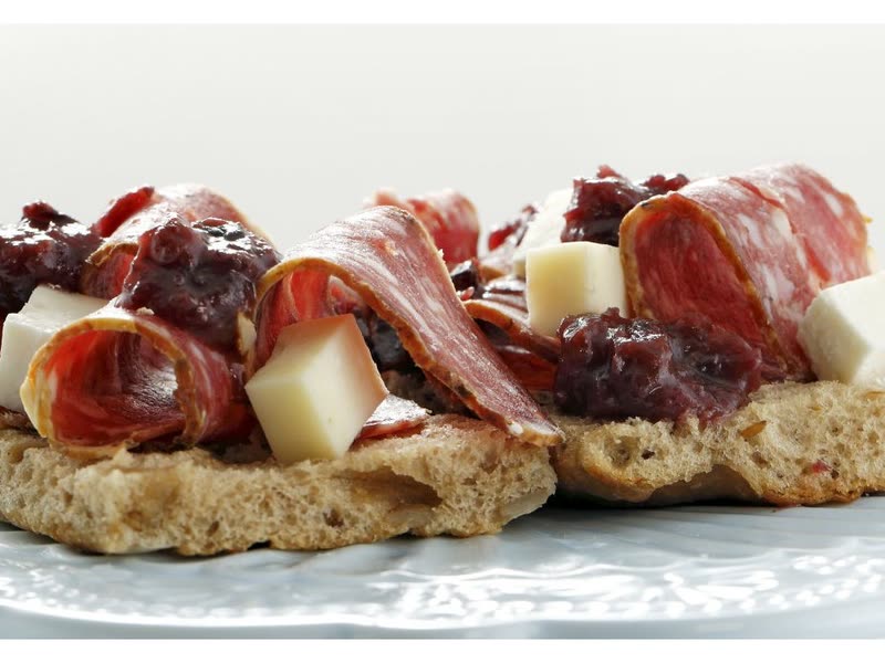 Crostini with cured ham, cheese and plum and radicchio chutney