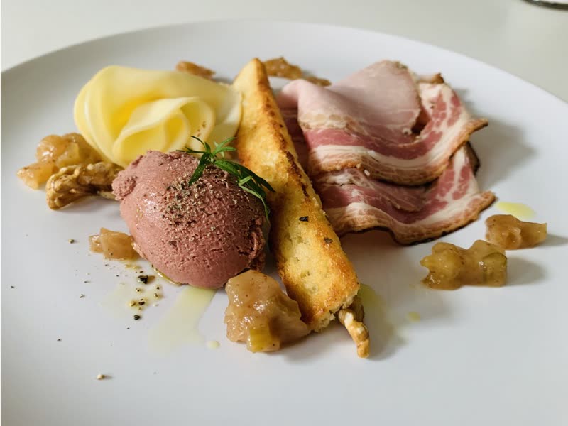 Plate of porchetta with chicken liver pâté and pear and celery chutney